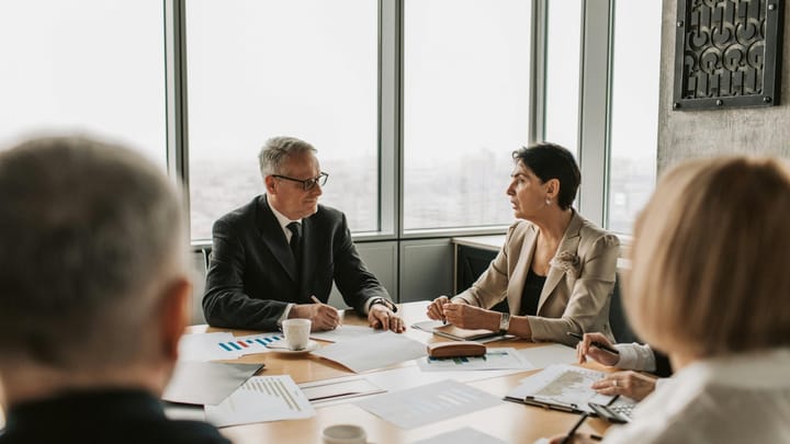 Executive leadership team reviewing financial documents during an enterprise AI RFP evaluation meeting in a modern boardroom.